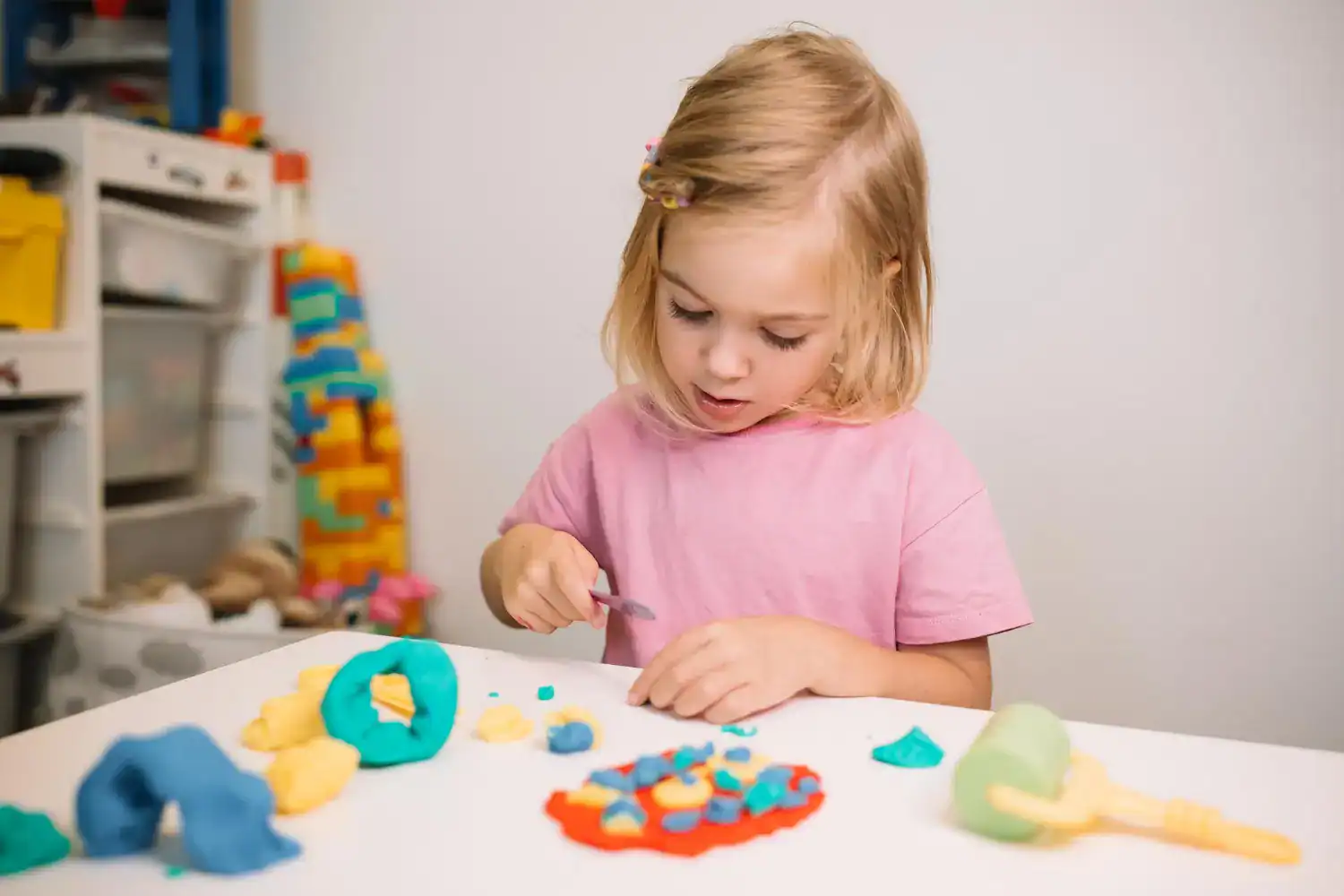 Young girl creating colorful New Year craft decorations for kids' celebration.