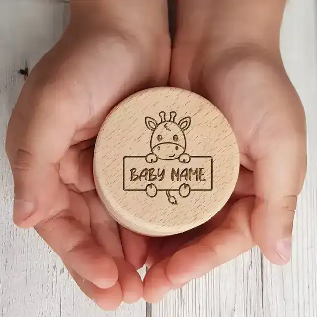 Personalized wooden keepsake for baby's first tooth with giraffe illustration and name space.