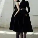 21 New Year’s Outfit Ideas for Women Woman in black evening dress with high heels, perfect for New Year's parties.