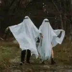 21 Funny New Year Outfits Ghost costumes with sunglasses for humorous New Year outfits.