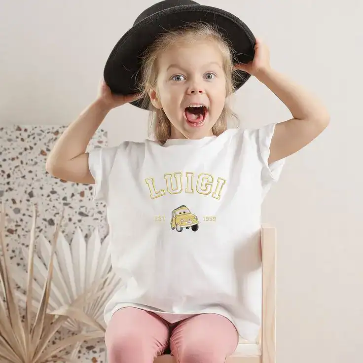 Cute girl wearing a hat and a personalized "Luigi" t-shirt for kids' birthday celebration.