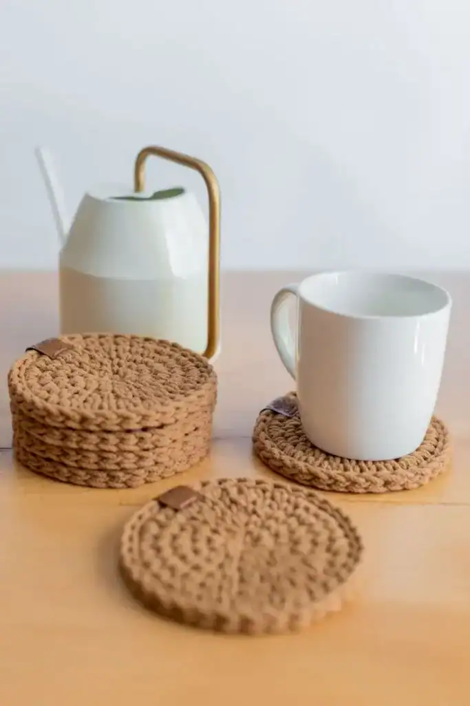Cozy woven coasters and modern ceramic mug for housewarming gifts.
