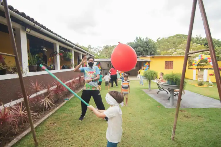 Kids playing balloon game at a carnival-themed birthday party.