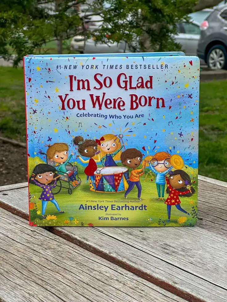 Children's birthday book titled "I'm So Glad You Were Born" with colorful illustrations of kids cele.