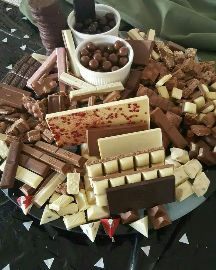 Chocolate bark party platter with assorted sweets and treats.