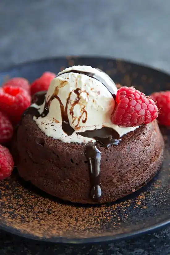 Warm chocolate lava cake with molten center, vanilla ice cream, and fresh raspberries — an intimate birthday dessert