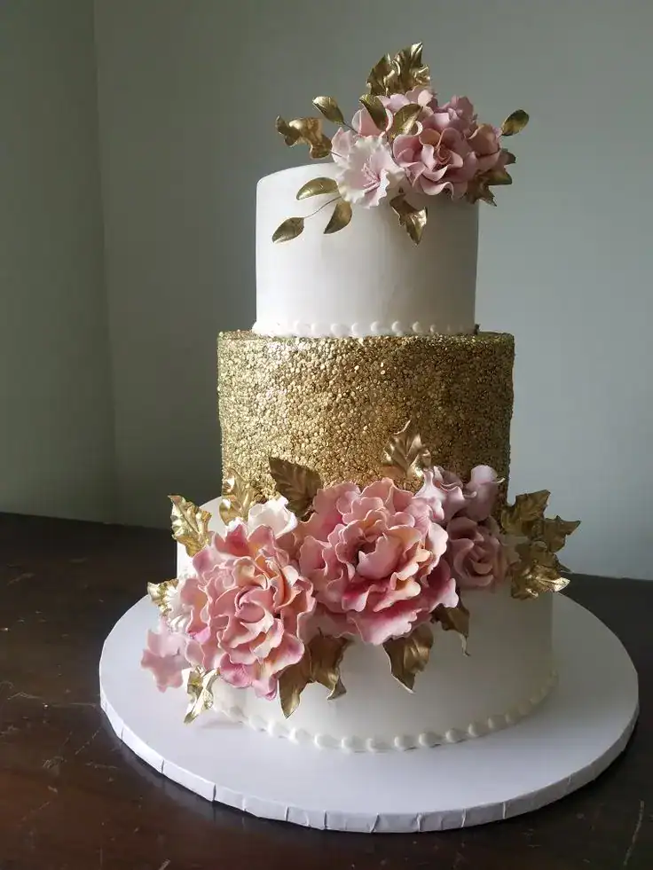 Rose gold birthday cake with metallic pink-gold buttercream finish and delicate floral decorations
