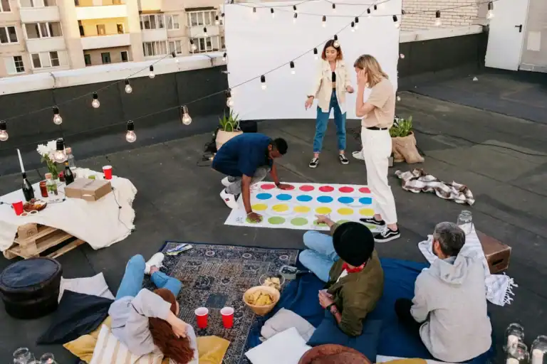 Fun rooftop game show party with friends and colorful Twister game.