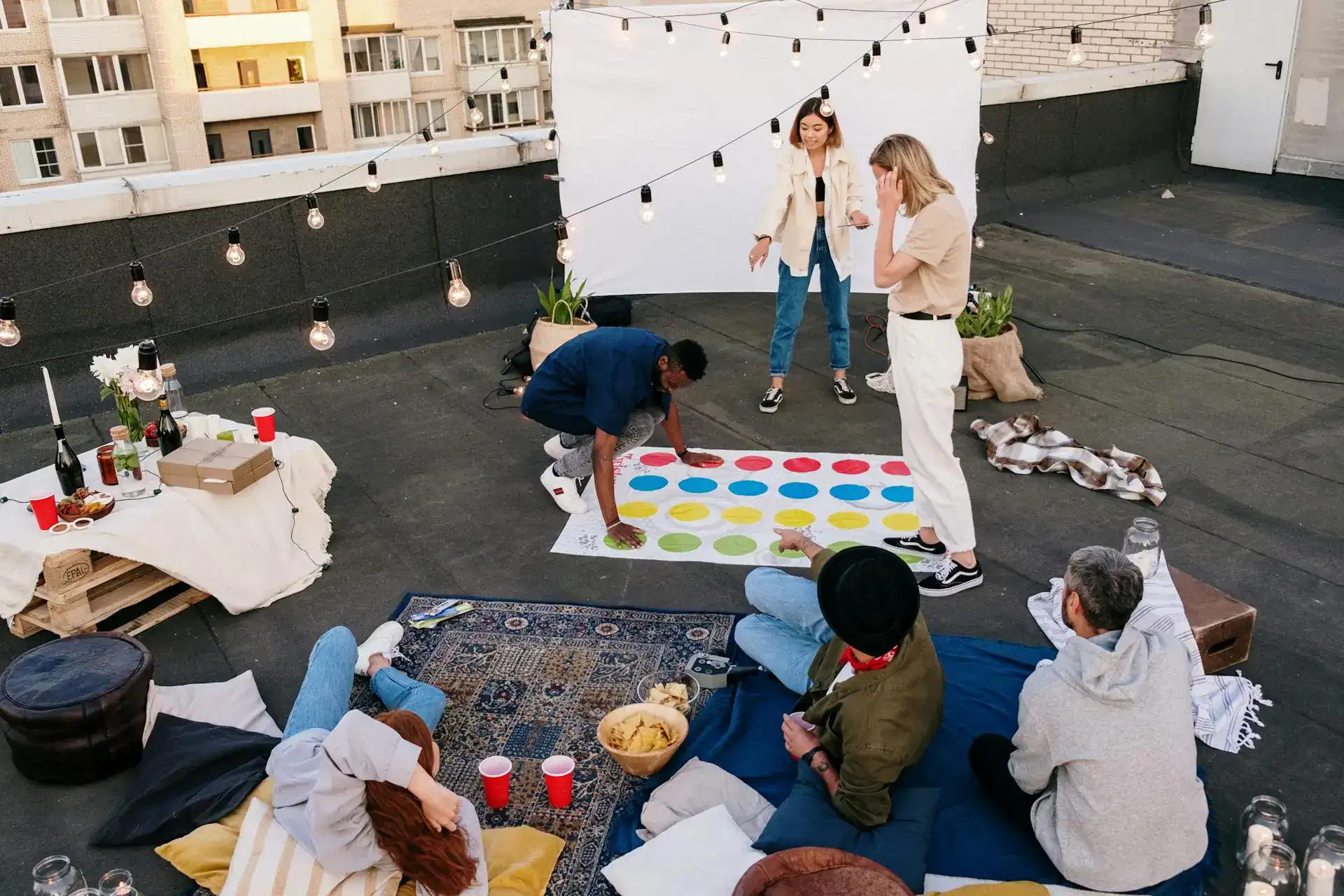 Fun rooftop game show party with friends and colorful Twister game.
