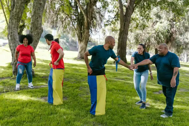Group of diverse people participating in a relay race outdoors in a park.