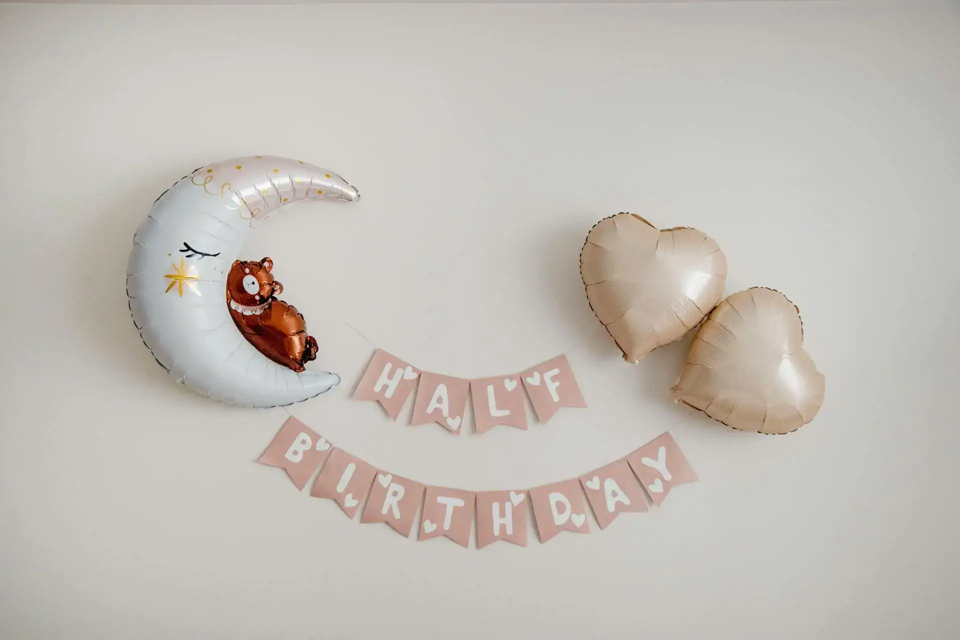 Cute moon and heart-shaped balloons for half birthday celebration.