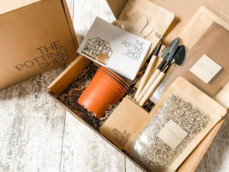 An image showcasing a housewarming gift box with gardening tools, seeds, and supplies for new homeow.