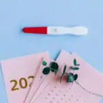 16 New Yearβs Baby Announcement Ideas Pregnancy test with positive result on blue background.