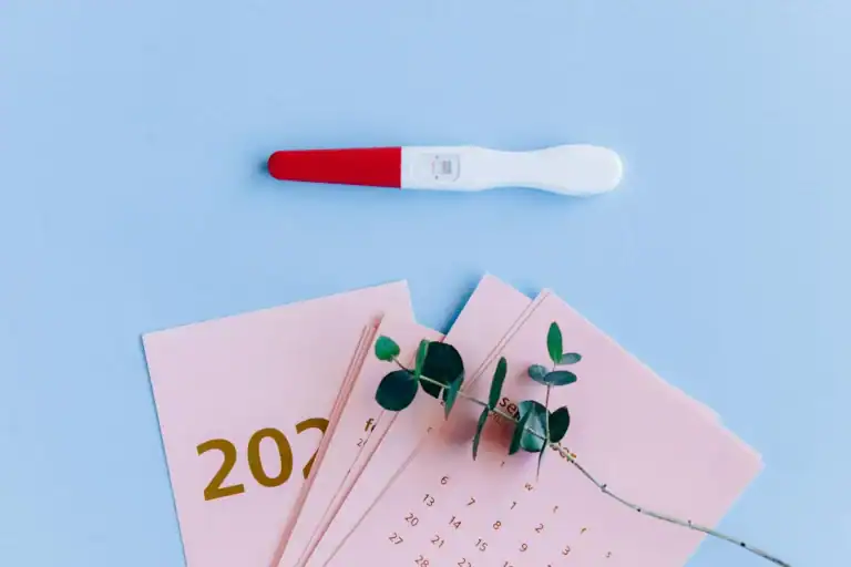 Pregnancy test with positive result on blue background.