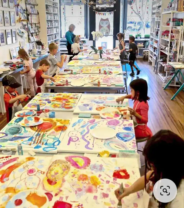 Children creating colorful artwork at a kids' art workshop in a vibrant store.