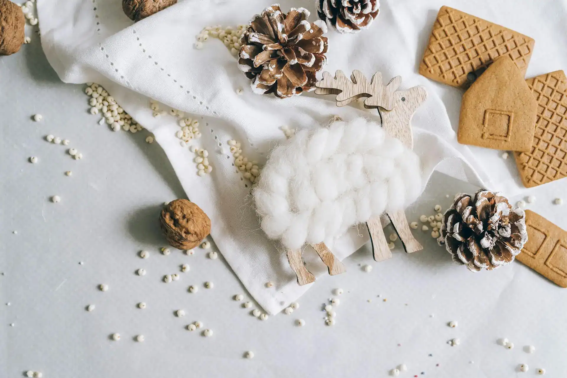 Cute winter-themed craft for toddlers with pinecones, gingerbread cookies, and plush reindeer decora.