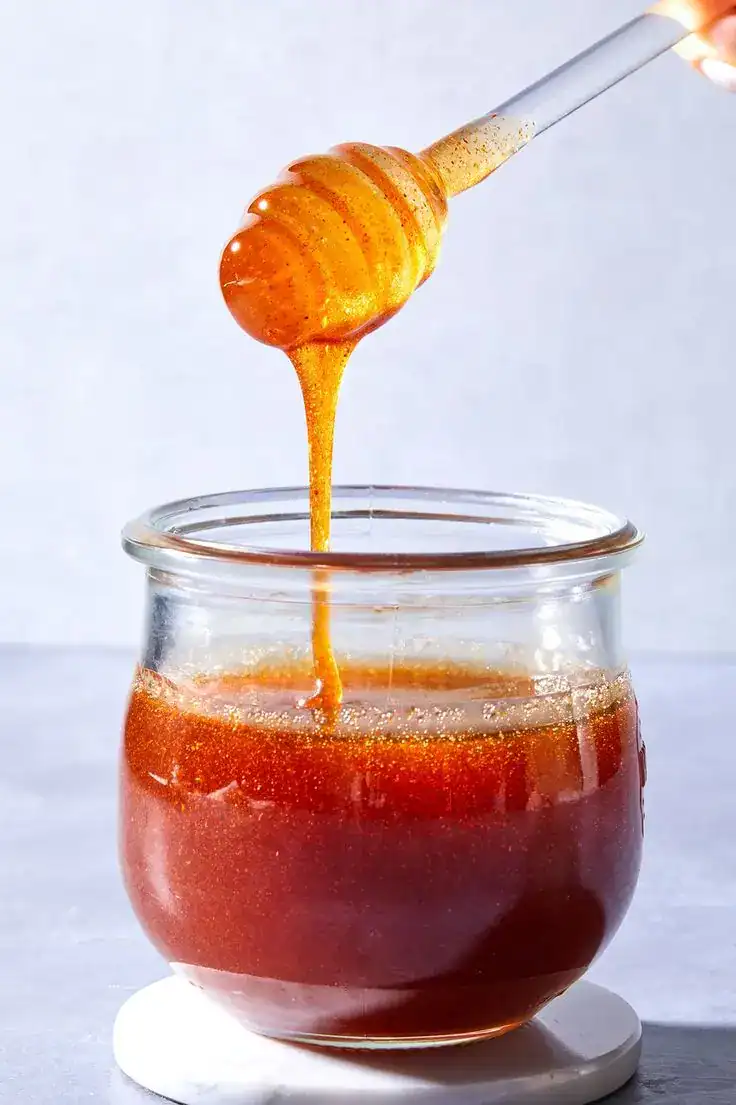 Honey being drizzled into a jar, perfect for housewarming party favors.