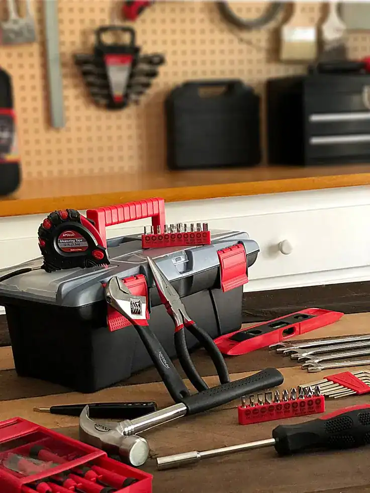 Tools and hardware for housewarming gift ideas, including a toolbox, hammer, screwdrivers, and measu.