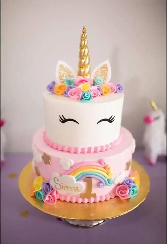 Unicorn-themed birthday cake with a gold fondant horn, pastel buttercream flowers, and edible glitter for a magical birthday party