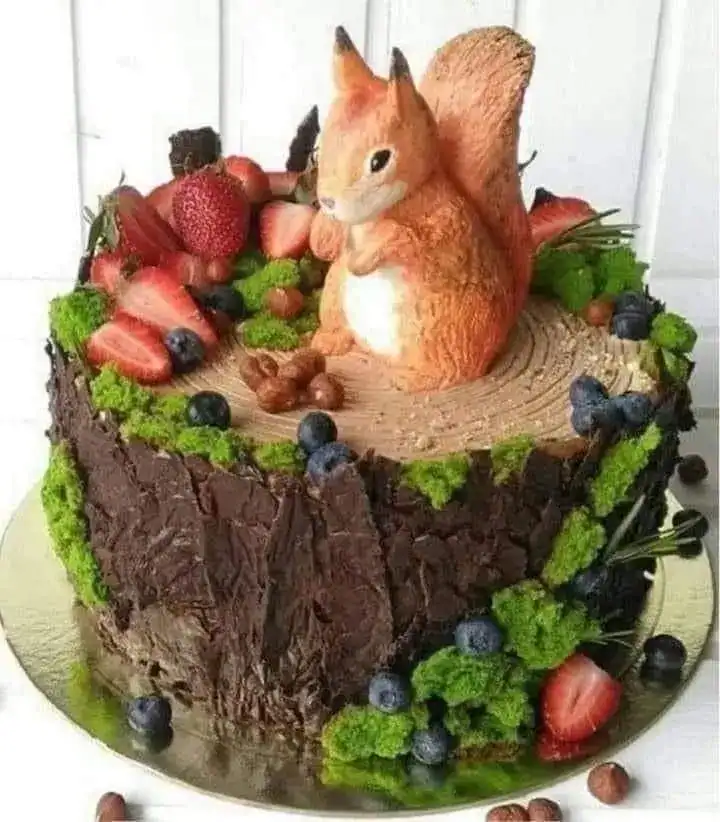 Woodland animal birthday cake with fondant squirrel, berries, and earthy green accents for a nature-themed party