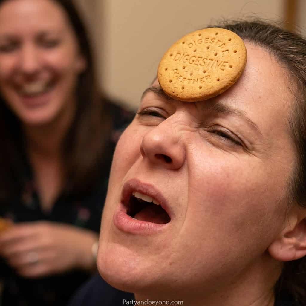 Woman with cookie on forehead during fun Valentine's Day game.