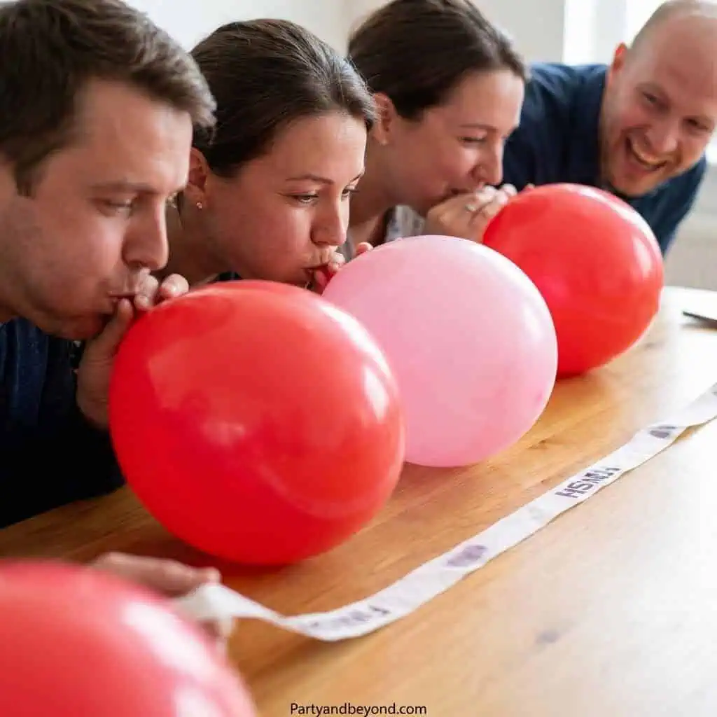 Group of people participating in a balloon pop game for Valentine's Day fun.