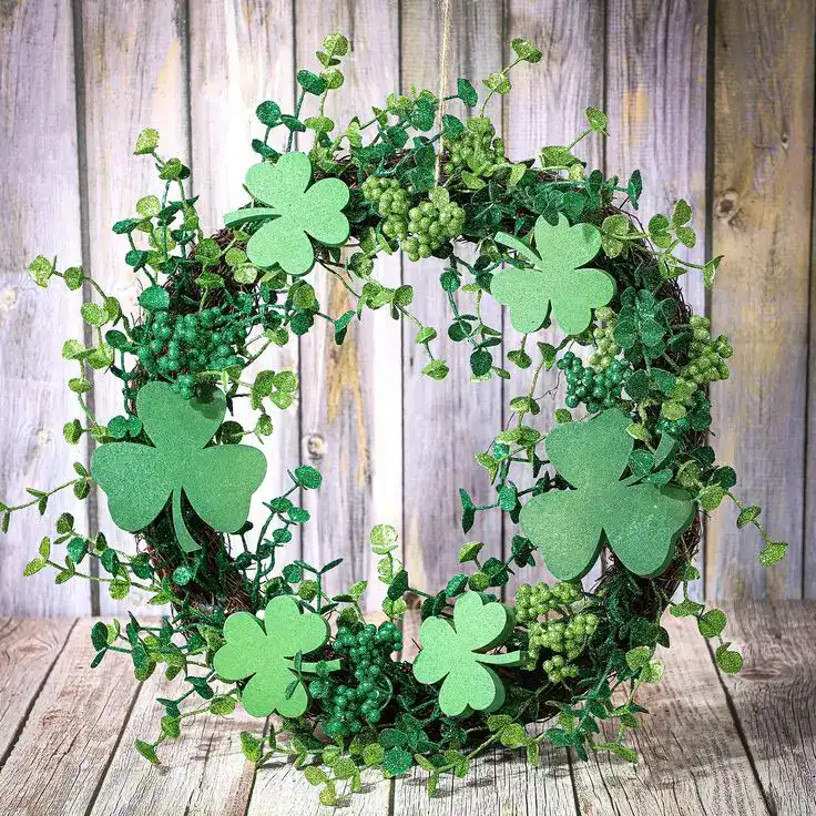 Green shamrock wreath with greenery for St. Patrick's Day celebrations.