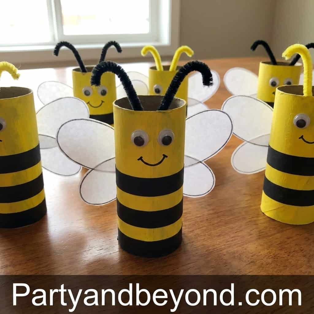 Colorful bee-themed craft using toilet paper rolls and pipe cleaners.