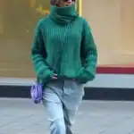 15 St. Patrick’s Day Outfit Ideas for Women Woman in green turtleneck sweater and jeans celebrating St. Patrick’s Day.