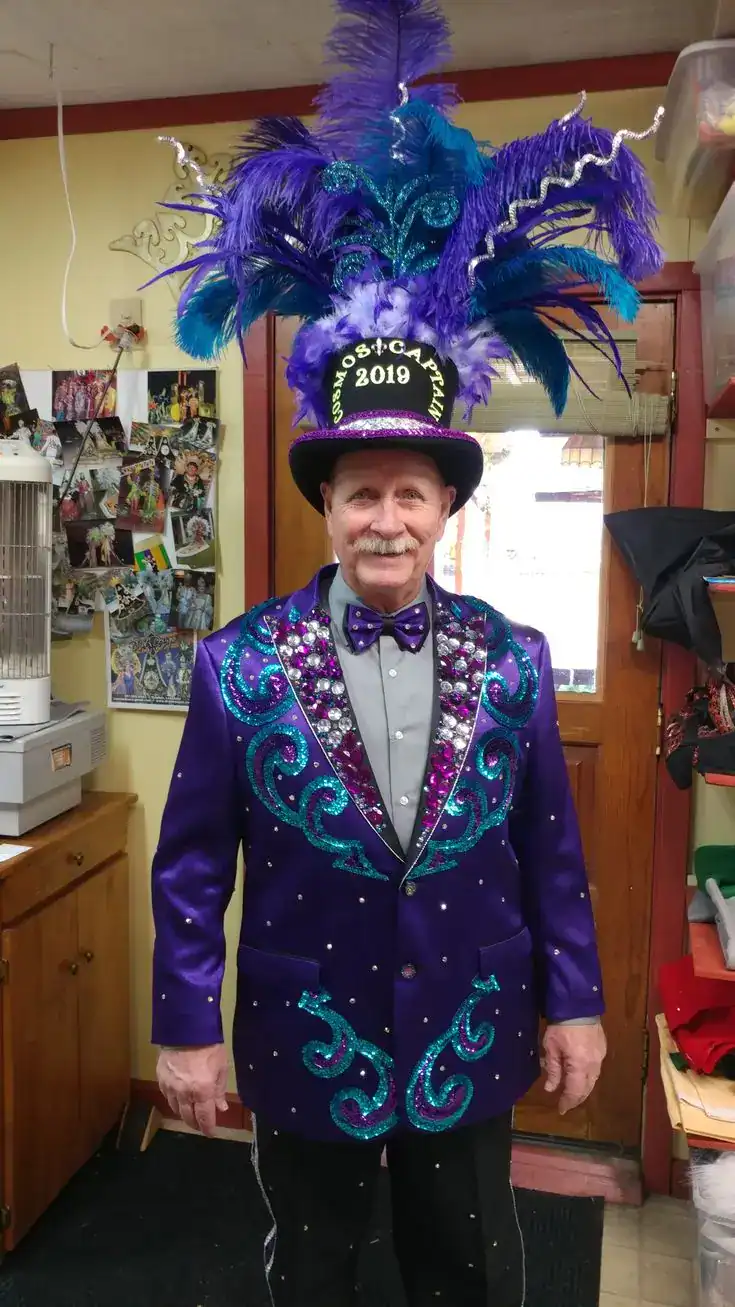 Colorful Mardi Gras parade costume with feathered hat and sequined jacket.