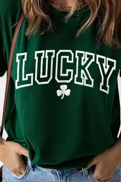 Woman wearing a green 'Lucky' St. Patrick's Day shirt with shamrock, perfect for festive celebration.