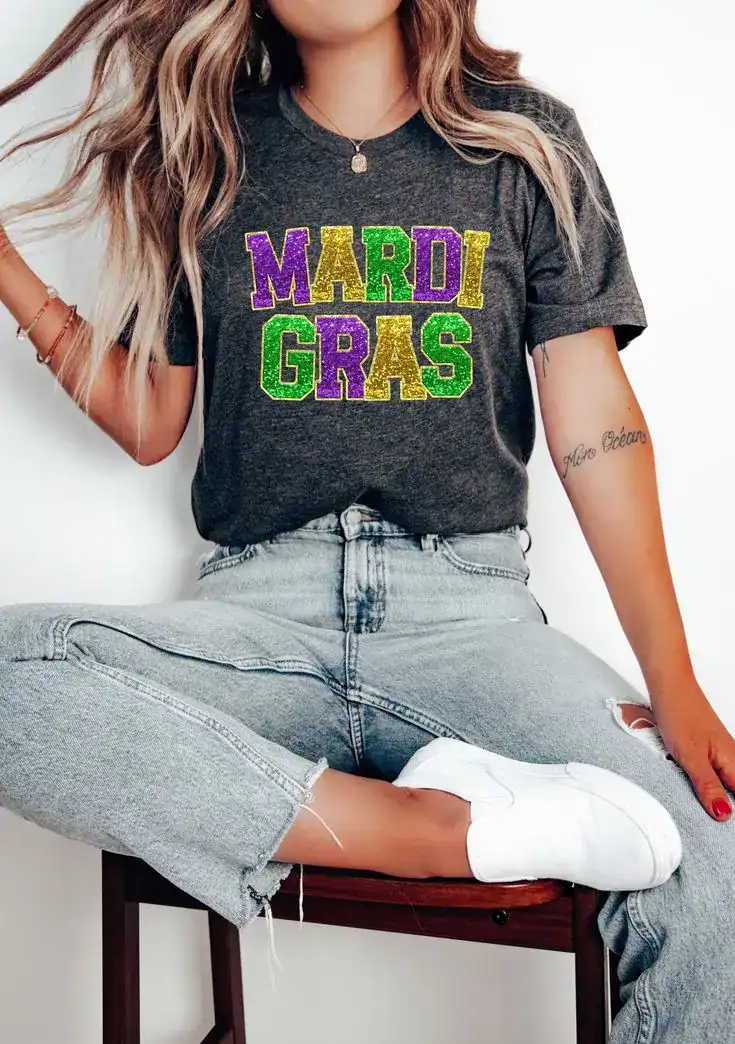 Mardi Gras themed T-shirt with colorful glitter text, perfect for Mardi Gras celebrations.