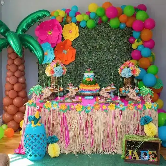 Colorful tropical summer birthday party setup with balloons, flowers, and themed decorations.