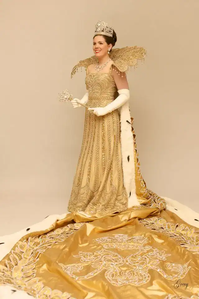 Elegant Mardi Gras queen costume with gold details and crown.