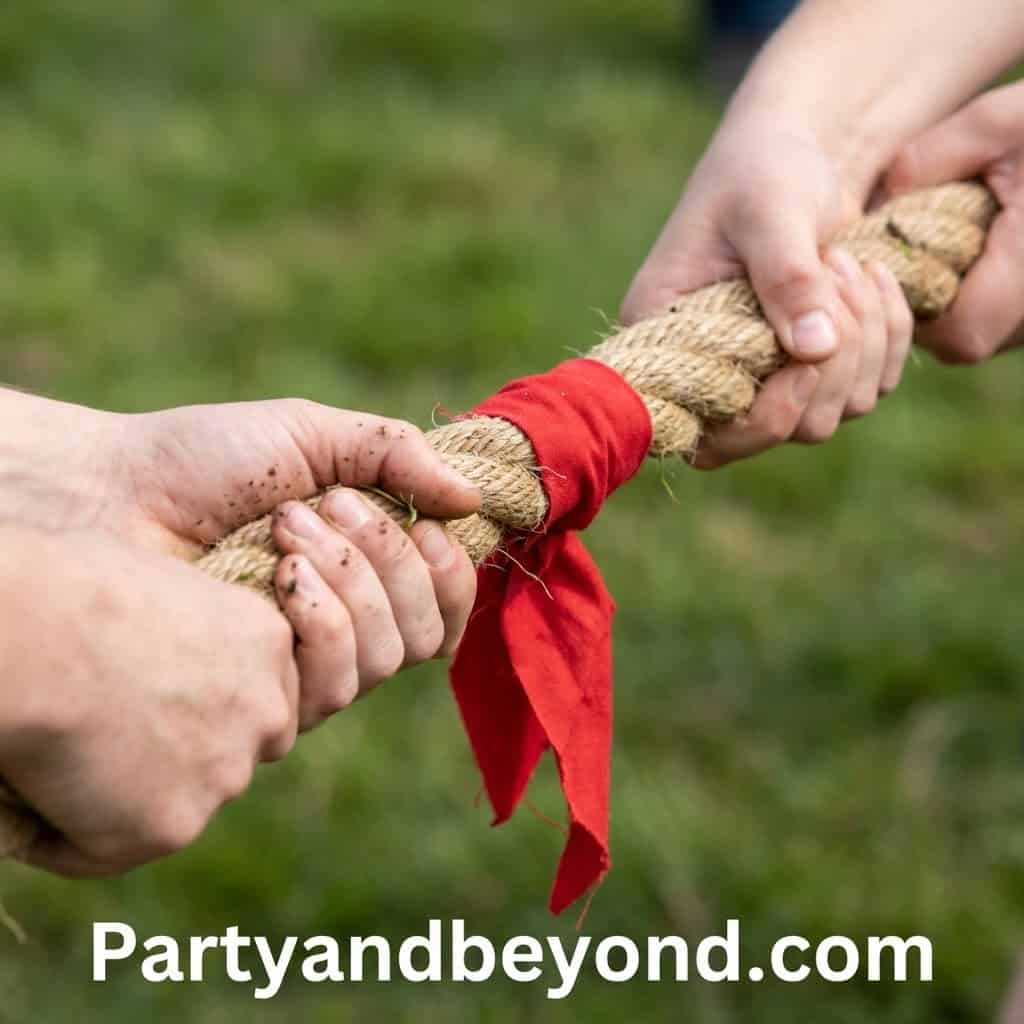 Children’s hands pulling a rope during a tug of war game at kids' field day event.
