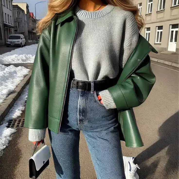 Woman in green leather jacket and jeans for an edgy St. Patrick's Day look.