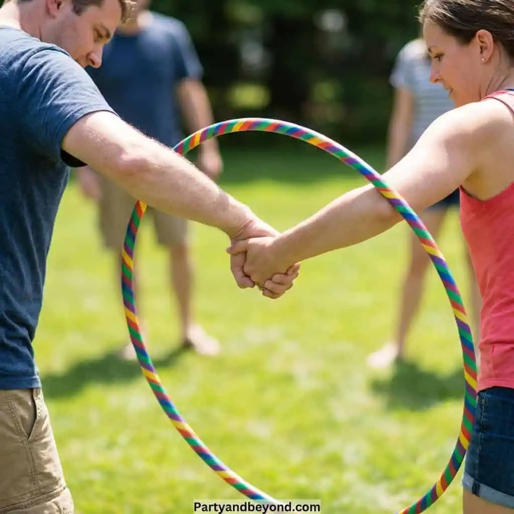 Kids and adults playing with a hula hoop outdoors during a fun field day event.