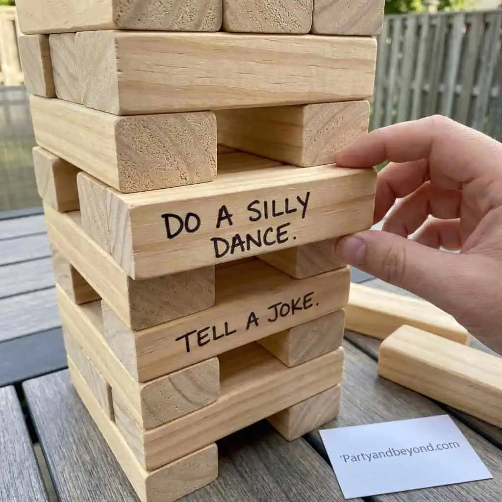 Jenga game with fun summer party prompts.