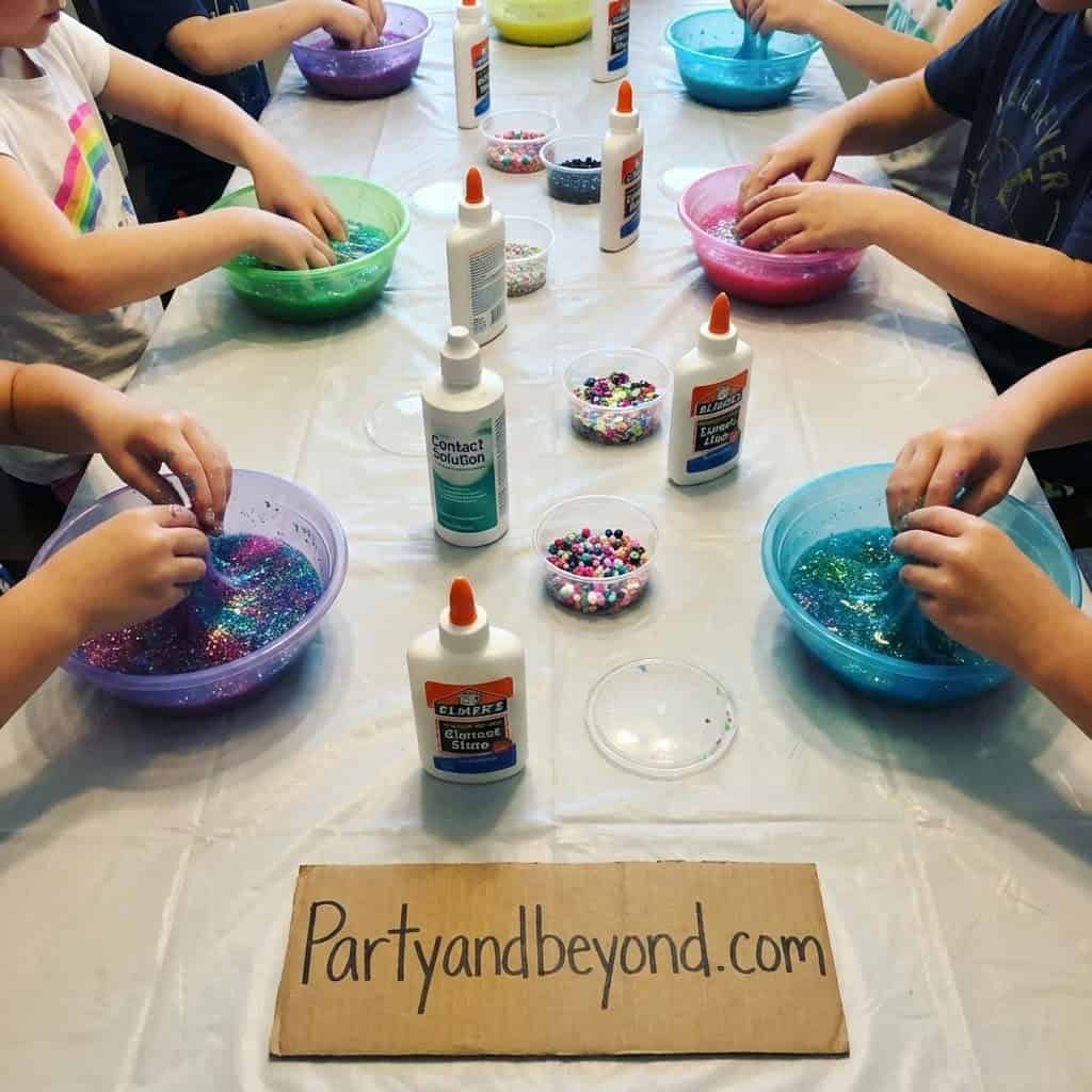 Kids making slime with glitter at a birthday party activity.