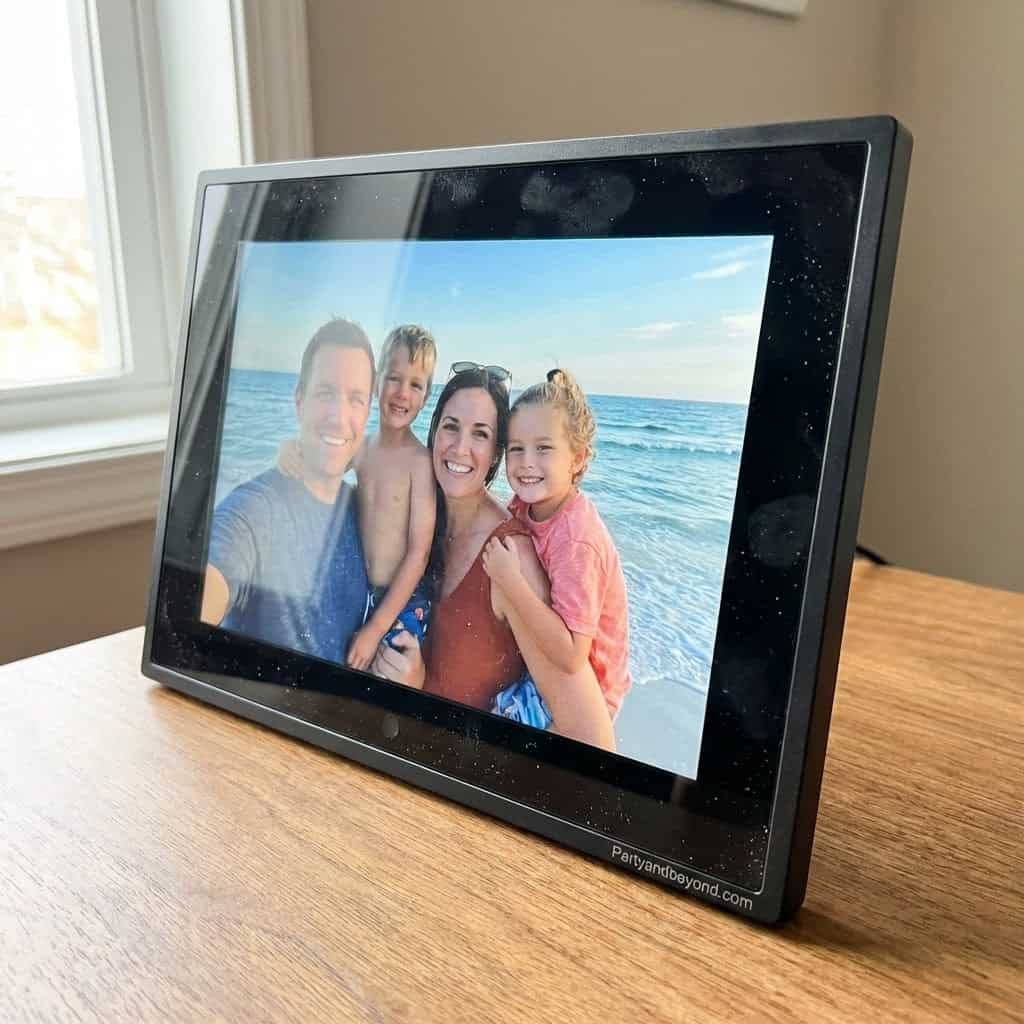 Digital photo frame displaying a happy family at the beach, perfect for personalized graduation gift.