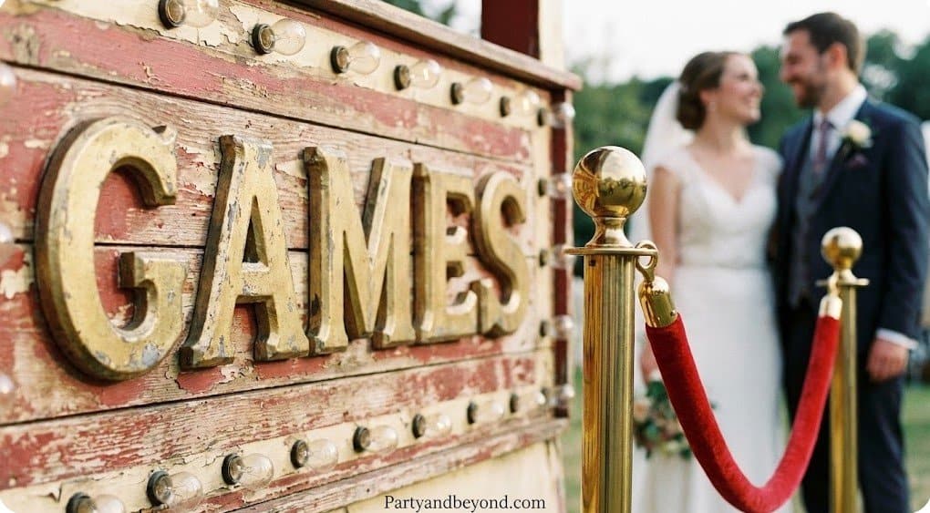 Wedding couple near carnival game sign at fun-filled wedding event.