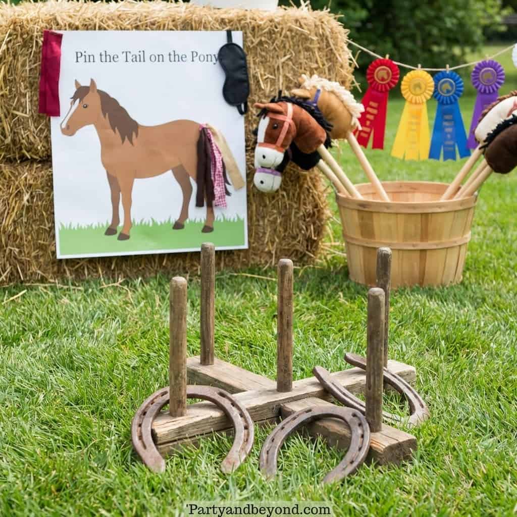 Pony tail pinning game at a cowgirl-themed birthday party with hay bales and ribbons.