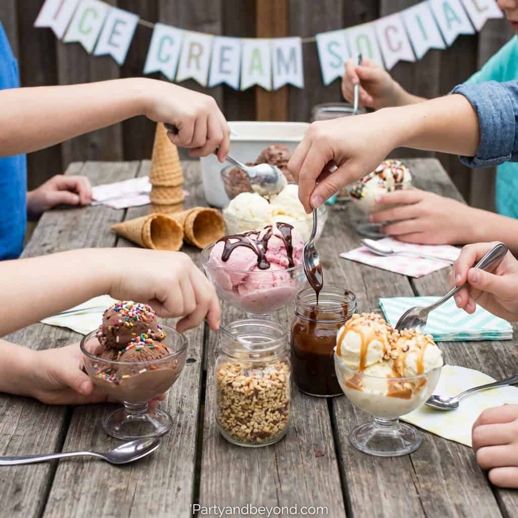 Kids enjoying ice cream sundaes at a summer birthday party.