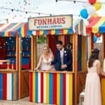 11 FunHaus-Inspired Carnival Wedding Games Guests Will Love Fun carnival wedding game booth with colorful stripes and balloons at a wedding event.