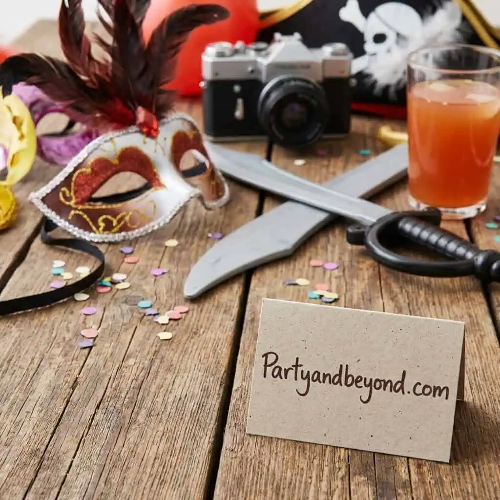 Mask, sword, and camera on a birthday party table.