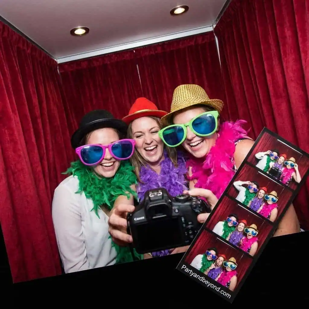 Fun group of friends at a house party wearing colorful oversized glasses and feather boas.