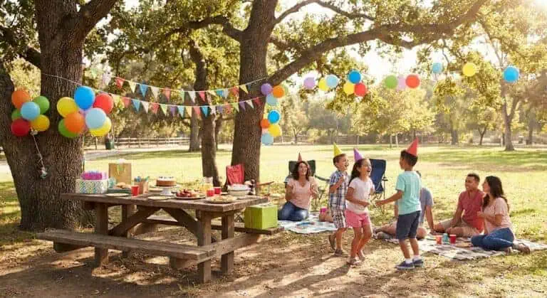 Outdoor kids' birthday party with colorful balloons and decorations.