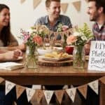 21 DIY Party Planning Ideas on a Budget for a Stylish and Affordable Event Group of friends enjoying a DIY photo booth at a stylish party event.