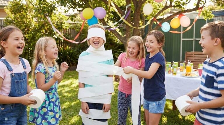 Children playing fun birthday party game outdoors.