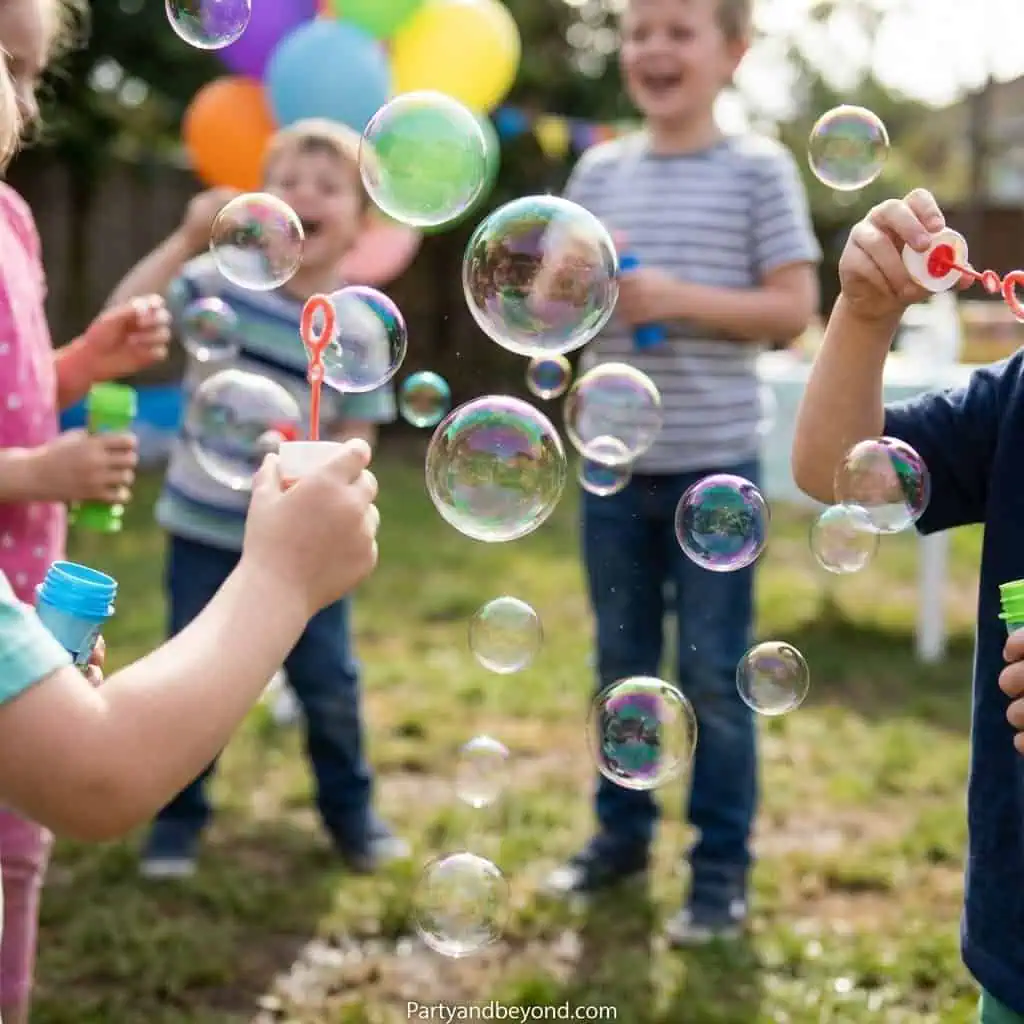 Kids blowing bubbles at a spring birthday party outdoors.